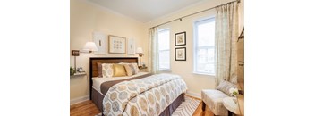 A bedroom with a large bed and a bench.