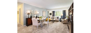 A dining room with a glass table and white chairs.