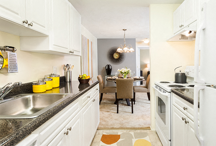A kitchen with white cabinets and a black stove top oven.