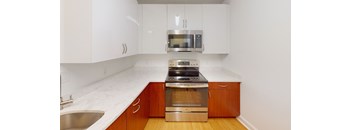 A modern kitchen with a stainless steel sink and wooden cabinets.
