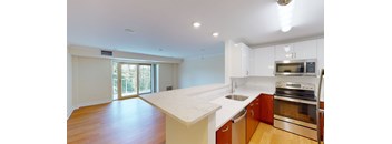 A kitchen with a white countertop and stainless steel appliances.