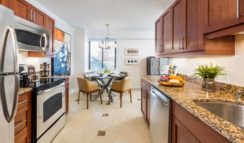 A kitchen with a table and chairs in the middle of it.