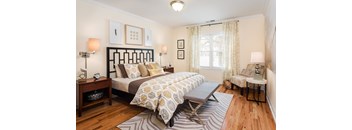 A bedroom with a large bed and a chair.