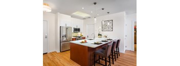 A modern kitchen with a center island and bar stools.