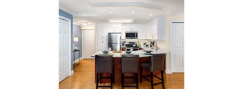 A kitchen with a table and chairs in the middle.