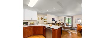 A modern kitchen with wooden cabinets and a large island.