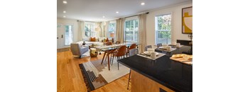 A modern kitchen and living room with a dining table and chairs.