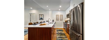 A modern kitchen with a wooden island and stainless steel appliances.