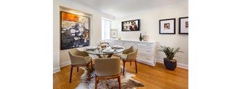 A dining room with a glass table and chairs.