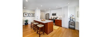 A kitchen with a bar and stools.