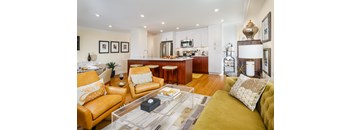 A modern living room with a yellow couch and a coffee table.