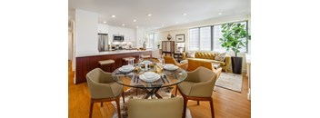 A modern dining room with a glass table and chairs.