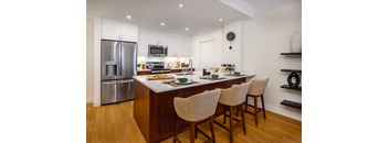 A modern kitchen with wooden floors and a central island.