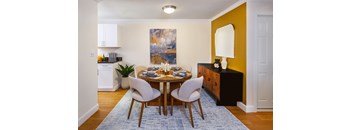 A dining room with a round table and chairs.