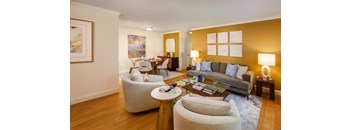 A living room with a grey couch, a white chair and a coffee table.