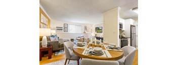 A dining room with a table set for a meal.