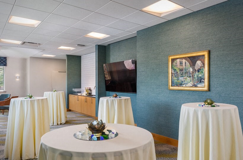 a conference room with white tables and chairs and a television