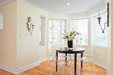 A dining room with a table and chairs.