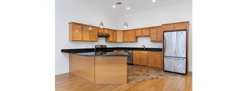 A kitchen with wooden cabinets and a black countertop.