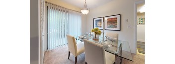 A dining room with a glass table and chairs.