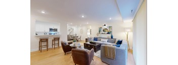 A living room with a grey couch and a yellow throw blanket.