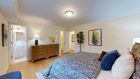 A bedroom with a bed, dresser, and mirror.