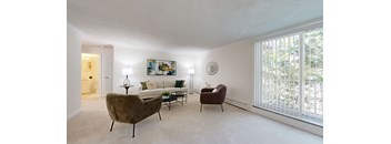 A living room with a brown chair, a white couch, and a painting on the wall.