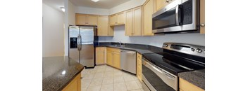 A kitchen with wooden cabinets and granite countertops.