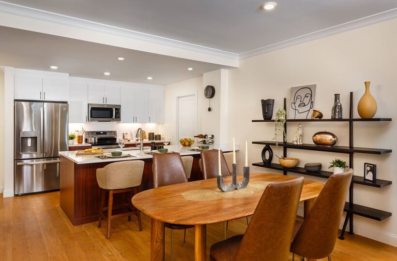 A modern kitchen with a wooden table and chairs.