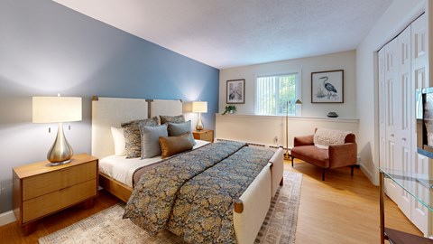 A bedroom with a large bed and a chair.