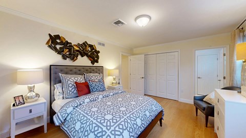 A bedroom with a large bed and a wooden sculpture on the wall.