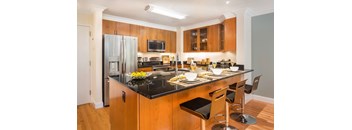 A kitchen with wooden cabinets and black countertops.