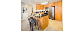 A kitchen with a black granite countertop and wooden cabinets.