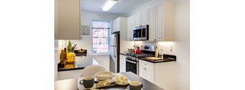 A kitchen with a table set for two with a bowl of food and a cup on it.