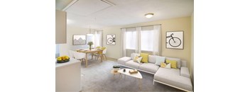 A living room with a grey couch, a dining table with chairs, a coffee table, and two bicycle pictures on the wall.
