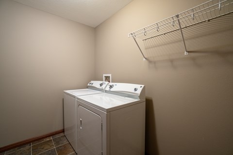A white sink is in a small room with a wall-mounted cabinet.
