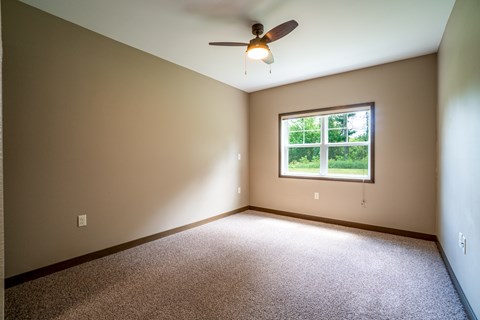 A room with a ceiling fan and a window.