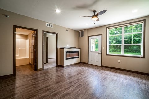 A room with a ceiling fan and a fireplace.