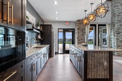 A modern kitchen with dark wood cabinets and a stone wall.