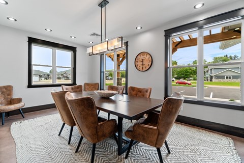 A dining room with a large table and chairs.