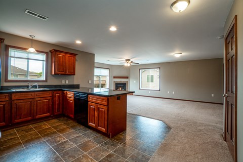 A kitchen with brown cabinets and a black countertop.
