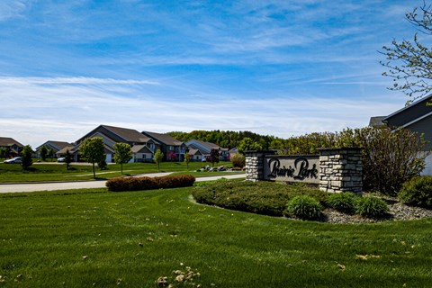 A sign that says "Pine Ridge" is in front of a grassy area.