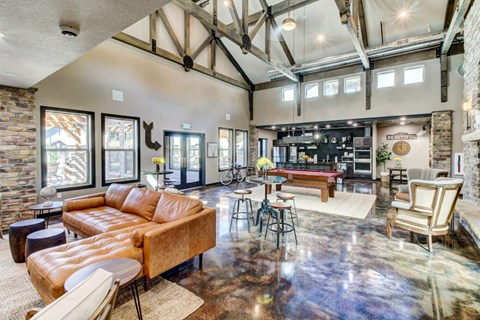 A living room with a brown leather couch and a wooden floor.