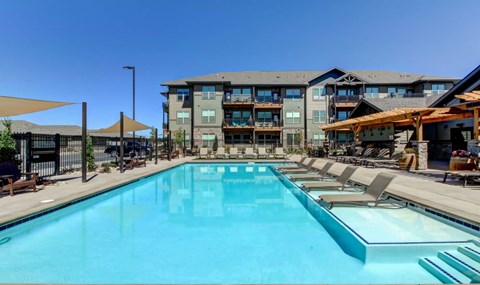 A large swimming pool in front of a multi-story building.