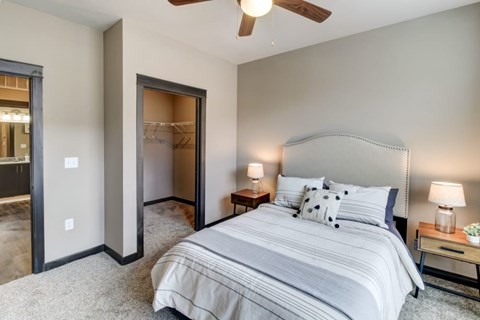 A bedroom with a large bed and a ceiling fan.