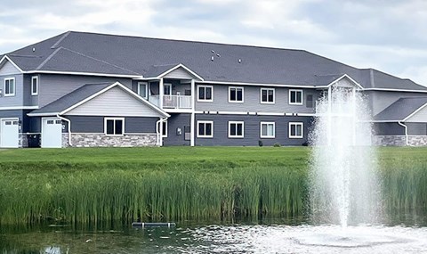 A house with a fountain in front of it.
