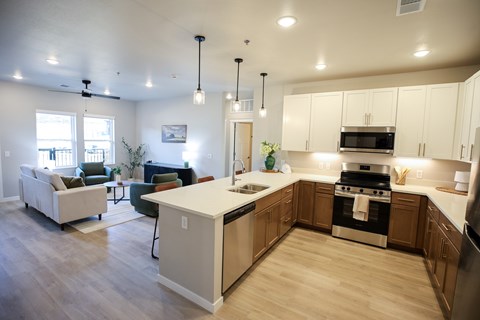 A modern kitchen with a white island and stainless steel appliances.