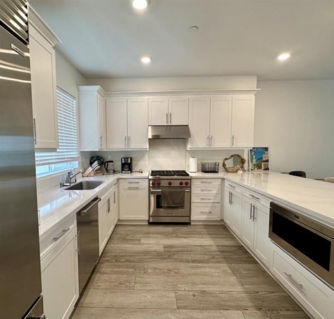 A modern kitchen with white cabinets and a central island.