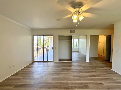 A spacious room with a ceiling fan and sliding glass doors.