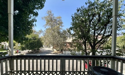 A view from a porch looking down a tree-lined street.